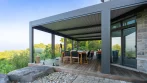 Pergola et terrasse reliées à de grandes portes coulissantes avec un ensemble de salle à manger extérieure