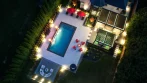 Backyard Pergola - photo 12 Top view of a backyard at night with a lit pool, patio and two louvered pergolas glowing with LED lights