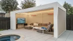White poolside pergola with warm LED lighting, two infrared heaters, a TV and a sectional sofa next to the pool spa